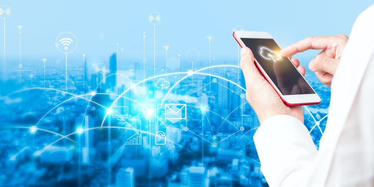 Man's hand using smartphone to connecting data information and blurred city background